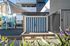 Modern apartment complex with shaded playground and striking blue striped wall, offering fun and relaxation for families.