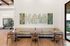 Chic and inviting dining area with modern decor, featuring cactus-themed artwork, cozy seating, and sleek wooden tables.