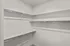 Spacious walk-in closet with ample shelving and hanging space in a modern apartment.
