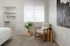 Chic bedroom corner featuring a cozy rocking chair, stylish plant, and an inviting open closet.