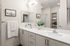 Sleek and modern bathroom with dual sinks, minimalist decor, and an elegant plant adding a touch of nature.