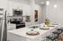Modern kitchen design with sleek white cabinetry, stainless steel appliances, and a chic island breakfast bar with stylish place settings.