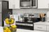 Modern kitchen with sleek stainless steel appliances, elegant white cabinets, and a stylish arrangement of colorful fruit for a vibrant touch.