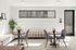 Modern lounge area with stylish decor, featuring two cozy seating arrangements, vibrant greenery, and large windows allowing natural light to fill the space.