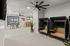 Modern communal workspace with stylish seating pods, sleek ceiling fans, and natural light from large windows.