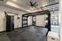 Modern fitness room with premium exercise equipment, featuring a sleek pulley machine, versatile workout station, and a TRX suspension trainer for diverse workouts.