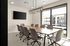 Modern conference room featuring a large table, comfortable chairs, and abundant natural light from floor-to-ceiling windows.