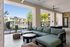 Elegant outdoor patio with comfortable seating area overlooking a pristine pool and lush landscaping.