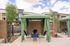 Charming outdoor seating area with green canopy and stylish chairs, perfect for relaxation and social gatherings amidst a modern apartment setting.