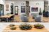 Modern communal area with stylish decor, featuring cozy seating, elegant wood flooring, contemporary artwork, and a spacious wooden dining table, perfect for socializing and relaxation.