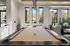 Luxury apartment lounge with stylish billiard table, elegant decor, and floor-to-ceiling windows offering scenic views.