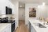 Modern kitchen with sleek stainless appliances, elegant white cabinetry, and a spacious island featuring stylish seating and contemporary lighting.