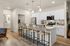 Modern kitchen with sleek white cabinetry, stainless steel appliances, and a spacious island with stylish bar seating.