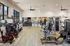 Modern fitness center equipped with state-of-the-art exercise machines, stationary bikes, treadmills, and weight lifting equipment, ideal for a health-focused lifestyle.