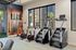 Modern fitness center featuring state-of-the-art stair climbers and exercise bikes with vibrant desert-themed wall art.