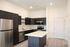 Sleek modern kitchen with dark wood cabinets, stainless steel appliances, and a spacious island countertop.