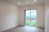 Bright and airy room with large sliding glass doors opening to a scenic mountain view, offering abundant natural light and modern flooring.