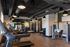 Modern apartment gym with state-of-the-art equipment, including treadmills and weight machines, well-lit with sleek industrial design.