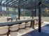 Chic outdoor patio with elegant wicker seating, modern pergola, and a sleek barbecue grill, perfect for entertaining.