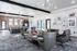 Chic and modern living space with elegant seating, stylish lighting, and artistic wall decor. Open-concept design with high ceilings and a gourmet kitchen in the background.