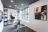Chic and modern home office with elegant decor, large windows, and cozy seating area.