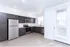 Modern kitchen with sleek dark wood cabinets, stainless steel appliances, and elegant recessed lighting.
