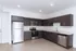 Modern kitchen with sleek dark cabinetry, stainless steel appliances, and spacious countertops.