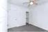 Bright and airy white room featuring a modern ceiling fan and an open closet space, perfect for a refreshing living experience.