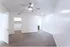Spacious bedroom with plush carpet, modern ceiling fan, and walk-in closet adjoining a bright en-suite bathroom.
