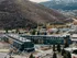Modern apartment complex nestled in a picturesque mountain setting, surrounded by vibrant autumn foliage and convenient urban amenities.