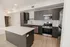 Modern kitchen with sleek cabinetry, stainless steel appliances, and a spacious white countertop.
