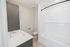 Modern bathroom with sleek white tiles, a contemporary vanity, and a luxurious bathtub, offering a serene escape.