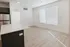 Bright and modern open-concept living space with sleek kitchen island and ample natural light through large window.