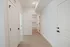 Bright interior hallway with modern white doors and elegant wood flooring leading to a stylish bathroom.