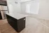 Modern kitchen with sleek stainless steel appliances, elegant white island, and sunlit hardwood floor.