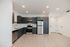 Modern kitchen design with sleek dark cabinetry, stainless steel appliances, and elegant recessed lighting on a light wood floor.