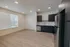 Contemporary open-plan kitchen and living area featuring sleek appliances, ample natural light, and elegant wooden flooring.