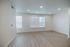 Bright and airy living room with modern recessed lighting, featuring large windows and elegant wood flooring.