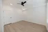 Elegant unfurnished room with modern ceiling fan, crisp white walls, and sleek hardwood flooring basking in natural light.