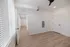 Bright and airy room with modern white walls, sleek wooden flooring, and abundant natural light streaming through large windows.