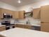 Modern kitchen with elegant wood cabinetry, sleek stainless steel appliances, and spacious countertop space, perfect for culinary enthusiasts.
