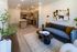 Contemporary open-concept living space featuring a modern kitchen with stainless steel appliances, cozy seating area, and vibrant artwork.