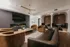 Elegant living room with modern decor, featuring plush armchairs, a sleek leather sofa, a wall-mounted TV, and cozy built-in booths, offering a perfect blend of luxury and comfort.