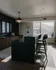 Elegant kitchen with a sleek black island, modern pendant lighting, and expansive mountain views through large windows.