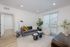 Contemporary living room showcasing a chic design with a plush gray sofa, vibrant gold cushions, modern coffee table, and abundant natural light from floor-to-ceiling windows.