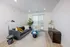 Modern and inviting living room with a sleek dark blue sofa, stylish floor lamp, and bright natural lighting from large windows.