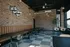 Chic urban seating area with modern industrial decor, exposed brick walls, stylish pendant lights, and cozy seating. Inviting neon sign with motivational message enhances the ambiance.