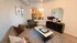 Chic and cozy living room featuring a stylish leather sofa, elegant armchair, and modern decor with large window and natural light.