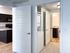 Modern apartment interior showcasing an efficient laundry area, sleek kitchen, and stylish bathroom with wood flooring.