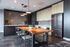Modern kitchen with sleek cabinetry, stainless steel appliances, and a stylish wooden dining table with pendant lighting.